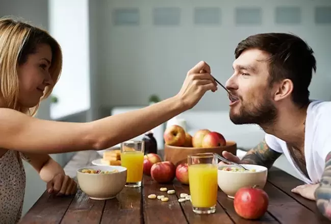 žena kŕmi muža orieškami, aby zvýšila potenciu